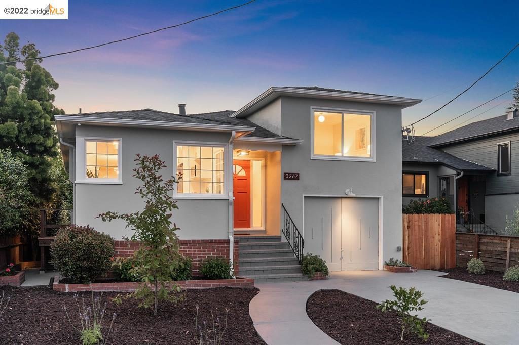 Exterior of a home in Maxwell Park that has been remodeled, light green stucco with orange colored door