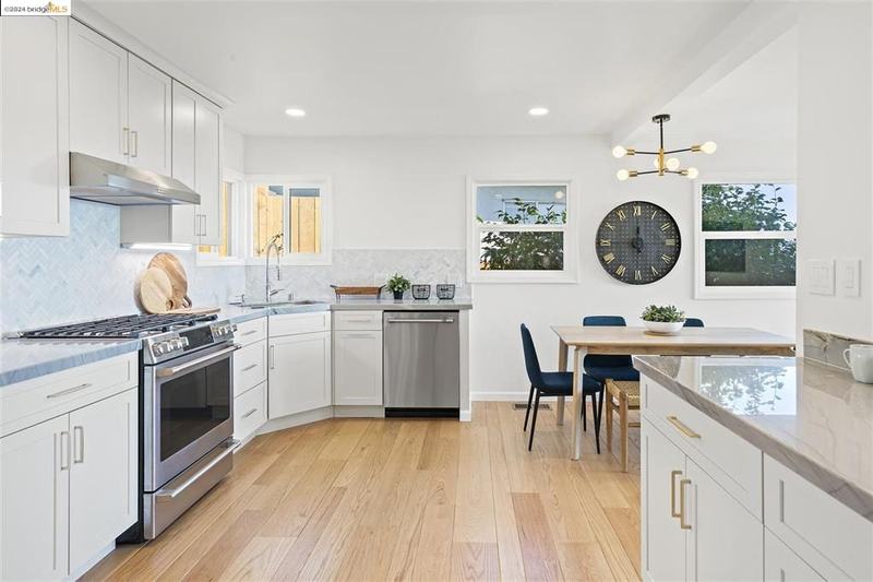 Spacious kitchen layout with quartzite countertops and marble backsplash