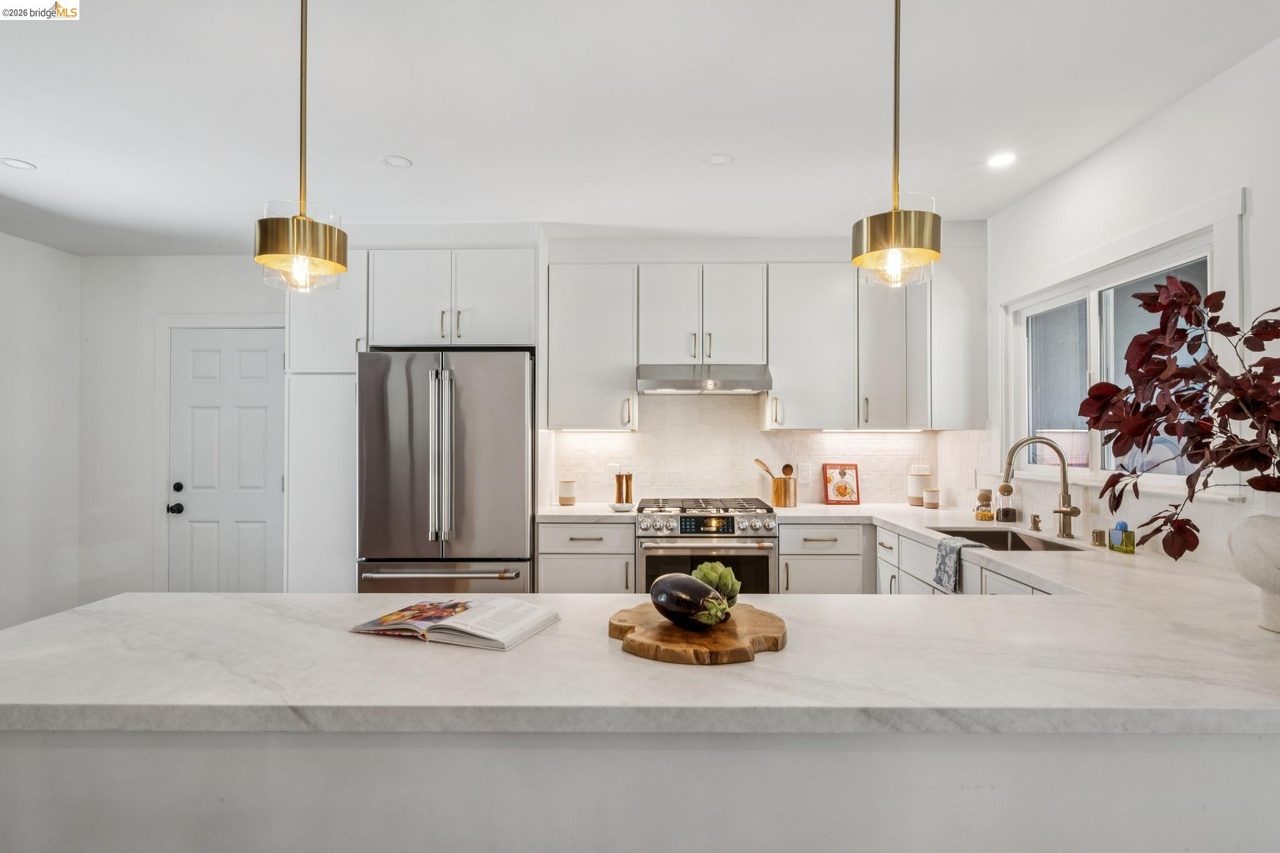Open kitchen design with peninsula, quartz countertops, pendant lights, and luxury appliances